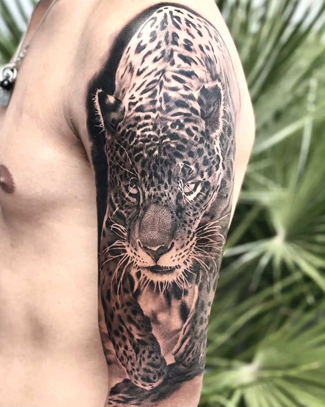 Giaguaro che avanza, tatuaggio realistico in bianco e nero sulla spalla